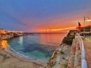a sunset over a body of water with a bench at Bella Gallery Terrasini in Terrasini