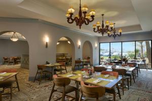 a restaurant with tables and chairs and a chandelier at Marriott El Paso in El Paso