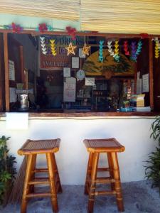 dois bancos de madeira sentados em frente a um bar em SUNSHINE PARADISE Inn em Ilha de Bantayan