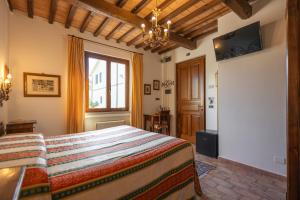 a bedroom with a bed and a window at Hotel La Fonte Del Cerro in Saturnia