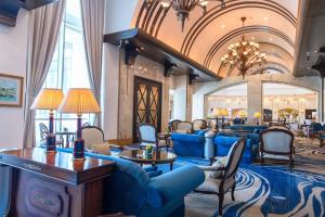 a hotel lobby with blue couches and chairs at The Ritz-Carlton, Doha in Doha