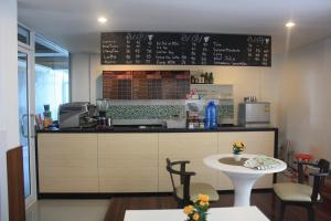 a kitchen with a counter and a table with chairs at Sukontha Mansion in Ban Khlong Naraphirom