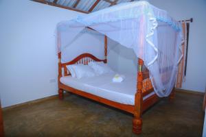 a bedroom with a bed with a canopy at Sunshadow Chalet in Tangalle