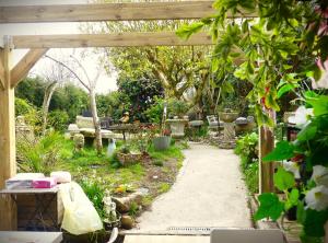 a garden with a pergola and a table and chairs at Chez Laurence in Locronan +14 photos