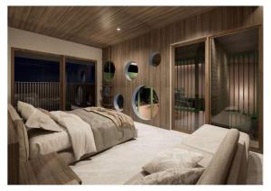 a bedroom with a bed and a couch and mirrors at The Foresta By Ohana in Timuran