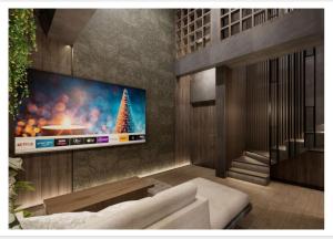 a living room with a television on a wall at The Foresta By Ohana in Timuran