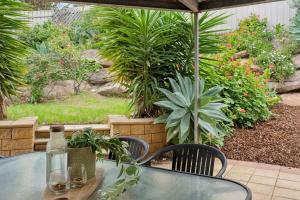 a glass table with two glasses on a patio at Sunset Ocean View Retreat 4BM House in Christies Beach