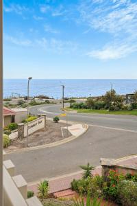 an empty street with the ocean in the background at Sunset Ocean View Retreat 4BM House in Christies Beach