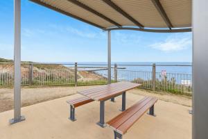 a picnic table with a view of the ocean at Sunset Ocean View Retreat 4BM House in Christies Beach