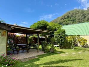 a picnic table in a yard with a green roof at Fare Miti Ora Moorea - Bungalow mitoyen in Hauru