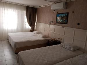 a hotel room with two beds and a window at Hotel Cems Sunparadise in Alanya