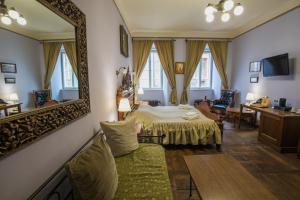 a bedroom with a bed and a large mirror at Hotel Edward Kelly in Český Krumlov