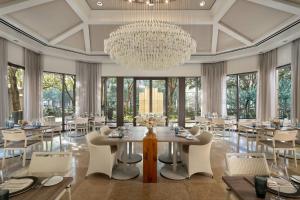 a dining room with a large chandelier and tables and chairs at The Ritz-Carlton, Dallas in Dallas