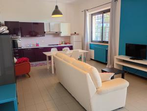 a living room with a white couch and a kitchen at Casa Don Peppì in Monopoli