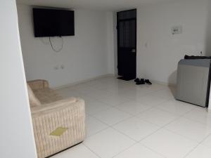 a living room with a chair and a television on a wall at Edificio Karu in Pamplona