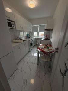 a kitchen with white cabinets and a table in it at Anastasia in Mangalia
