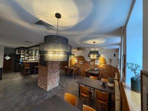 a room with a fireplace and a table and chairs at Penzion Janoštík in Rožnov pod Radhoštěm