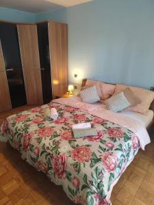 a bedroom with a bed with a floral blanket at Villa Bella Vista - For up to 6 people Villa with Sea & Castle view in Črni Kal