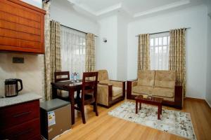 a living room with a table and chairs and a desk at Pakihotels&apartment in Moshi +19 photos