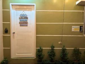 a door with a sign on it next to some plants at LoveCo Vacation house close to Dahilayan with private parking in Manolo Fortich