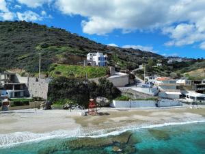 a chair on the beach in front of a mountain at Theasea beachfront luxury residence in Ligaria
