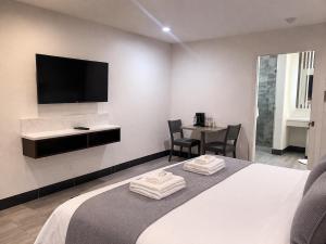 a hotel room with a bed with two towels on it at Motel Moonlight in Anaheim