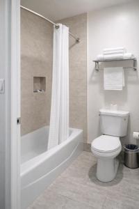 a bathroom with a toilet and a tub and a shower at Motel Moonlight in Anaheim