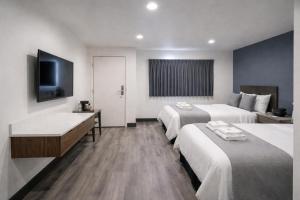 a hotel room with two beds and a bathtub at Motel Moonlight in Anaheim
