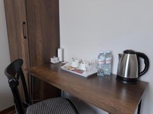 a table with a tea kettle and drinks on it at Orion Hotel in Almaty