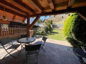 a patio with a table and chairs under a wooden roof at Chalupa Lipka in Kolárovice