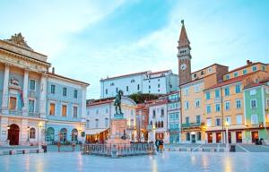 a city square with a statue and a clock tower at Blue Bay Apartment Piran in Piran