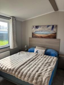 a bedroom with a large bed and a window at NEU Chalet Wattenmeerblick 2026 in Westerland