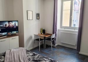 a bedroom with a table and a tv in a room at Studio lumineux in La Chaux-de-Fonds