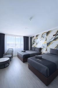 a hotel room with two beds and a couch at Neela House in Labuan
