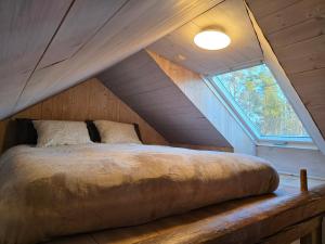 a bed in the middle of a attic with a window at Norra Vilan - Hagalund in Kopparberg