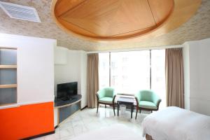 斗六市にある享平方文旅のベッド、テーブル、椅子が備わるホテルルームです。