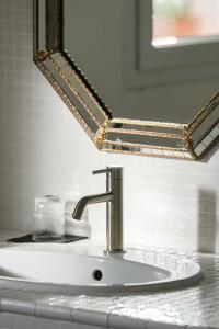 a bathroom sink with a mirror and aaucet at Maison d'hôtes Urbegia in Ascain