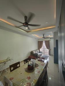 a living room with a table and a ceiling fan at Kalista1 Seremban 2 in Seremban