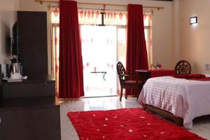 a bedroom with a bed and a window with red curtains at White Peacock Resort Mtwapa in Mombasa