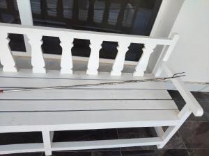 a white bench sitting in front of a window at منزل للإيجار اليومي in Ḩilf