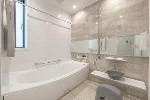 a white bathroom with a tub and a sink at Charm Roger Luxury Room 2 in Kamakura +8 photos