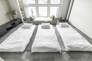 a large white bed in a room with a couch at Charm Roger Luxury Room 2 in Kamakura