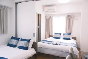 a bedroom with two beds and a window at The Peak Tsutenkaku Apartment Hotel in Osaka