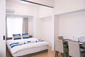 a bedroom with a bed and a desk and a deskablish at The Peak Tsutenkaku Apartment Hotel in Osaka