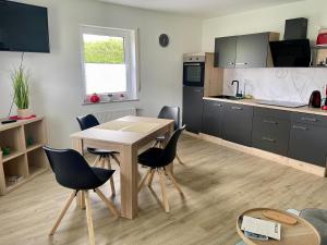 a kitchen with a table and chairs in a room at Mosel mit Herz in Cochem +1 photo