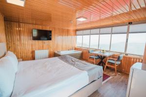 a bedroom with a bed and a table in a boat at Montana Resort Otel in Trabzon