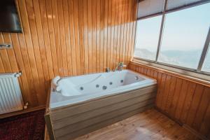 a bath tub in a wood paneled bathroom with a window at Montana Resort Otel in Trabzon +95 photos
