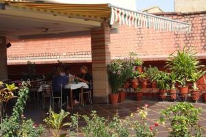 2 personnes assises à une table sur un patio dans l'établissement Hotel Sweet Dream, à Jaipur