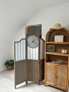 a clock on a door next to a shelf at Le CappyToiT - Gîte climatisé in Cappy