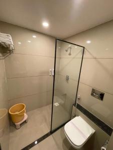 a bathroom with a toilet and a glass shower at Hotel Mahavir in Ankleshwar